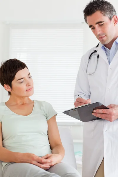 Αρσενικό γιατρός και Θηλυκός ασθενής κοιτάζοντας ένα γράφημα — Φωτογραφία Αρχείου