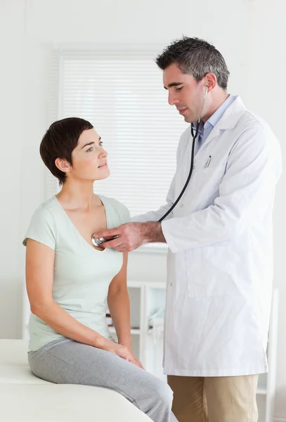 Medico esaminando una donna bruna — Foto Stock
