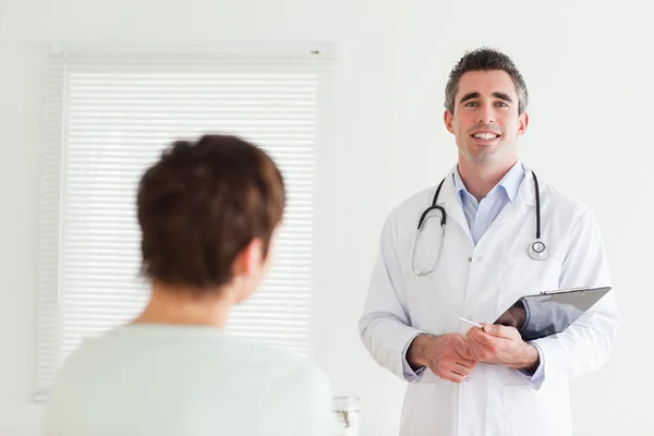 Sorridente medico parlando con una donna bruna — Foto Stock