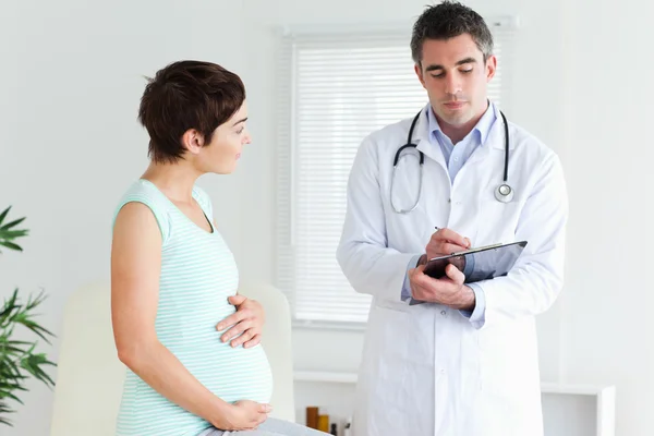 Mujer embarazada hablando con su médico — Foto de Stock
