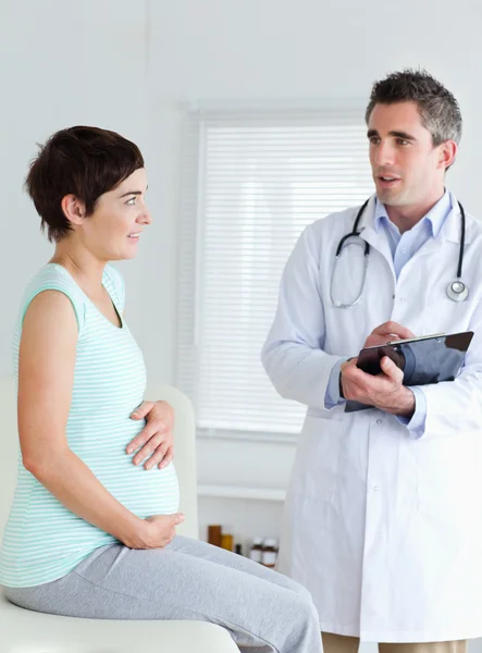 Zittende zwangere vrouw aanraken haar buik — Stockfoto
