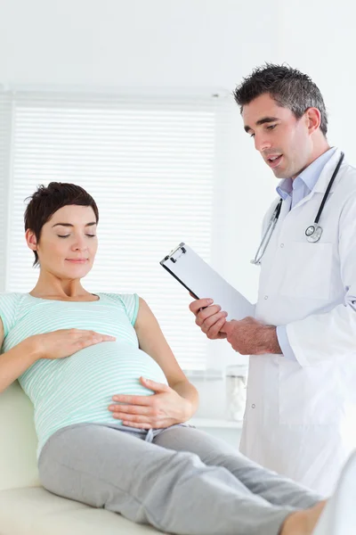 Kobieta w ciąży czarujący dotykając jej brzuch — Zdjęcie stockowe