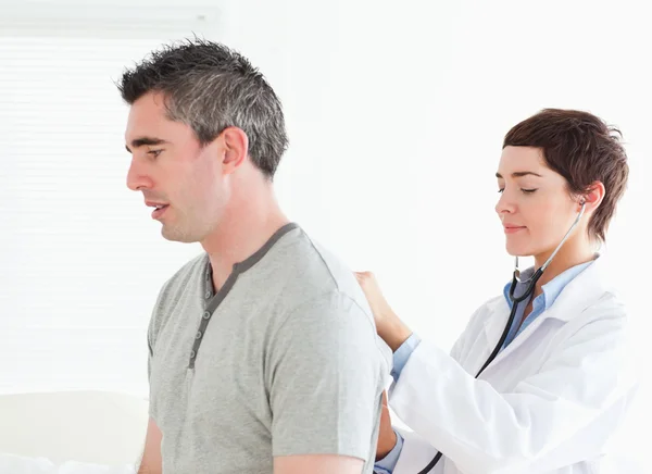 Женщина-врач осматривает пациента-мужчину — стоковое фото