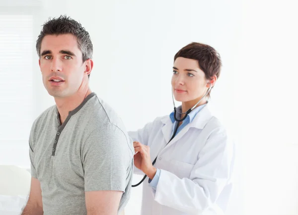 Medico esaminando il suo paziente con uno stetoscopio — Foto Stock