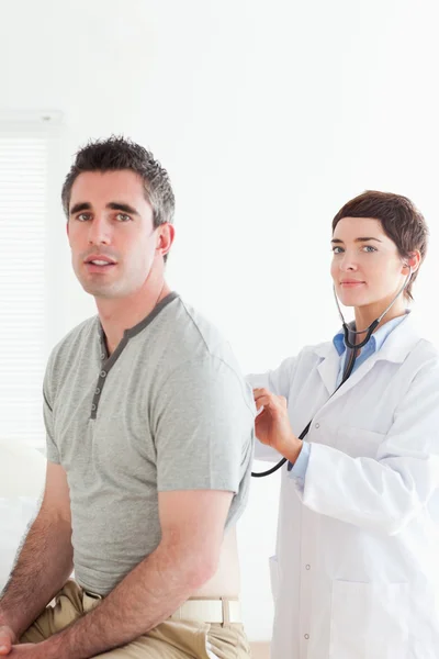 Tatlı doktor hasta bir stetoskop ile incelenmesi — Stok fotoğraf