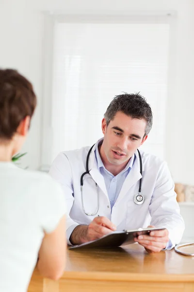 Pohledný doktor mluví s bruneta pacienta — Stock fotografie