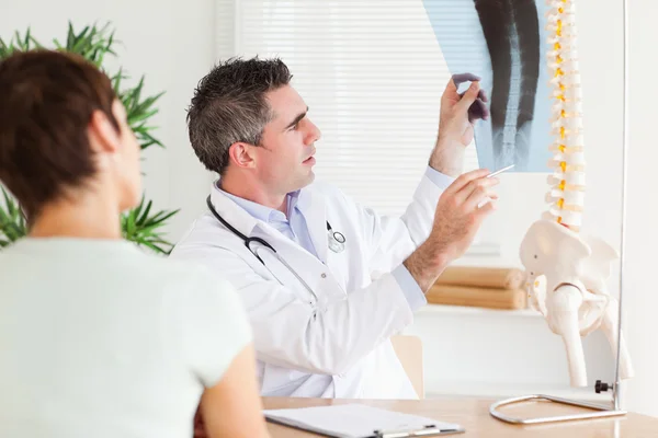 Manliga läkare visar en kvinnlig patient en röntgen — Stockfoto