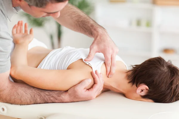 Man massaging a woman's shoulder — Stock Photo, Image