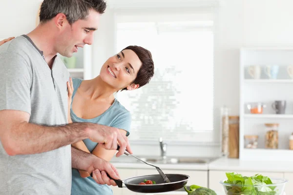 Woman smiling at her pan-holding husband — Stock Photo, Image