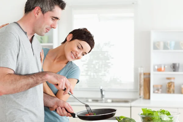 Vrouw op zoek naar een pan die haar man houdt — Stockfoto