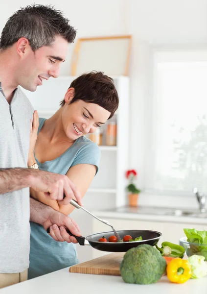 Gorgeous Woman looking into a pan her husband is holding — Stock Photo, Image