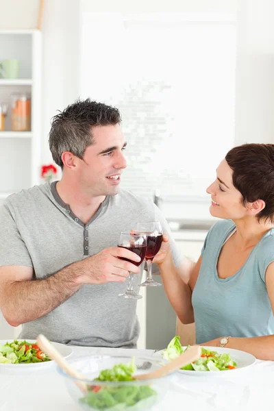 Glückliches Paar stößt mit Rotwein an — Stockfoto