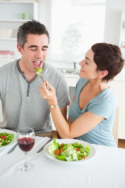 Charming woman feeding her husband — Stock Photo, Image