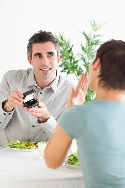 Мужчина делает предложение своей удивленной девушке во время ужина — стоковое фото