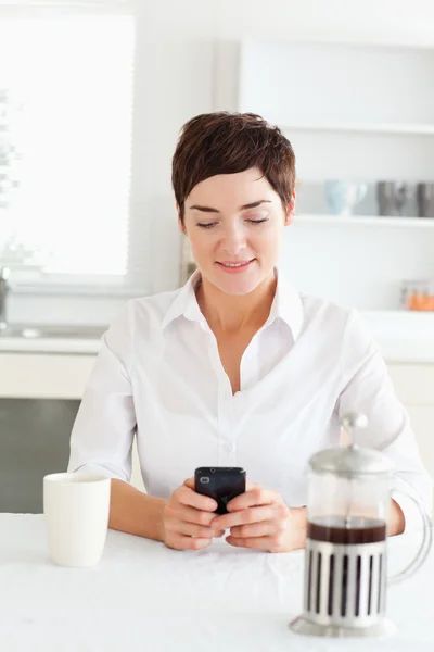 Mulher com café olhando para o seu telefone móvel — Fotografia de Stock