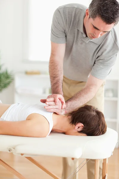 Massagista massageando o pescoço de um cliente feminino — Fotografia de Stock