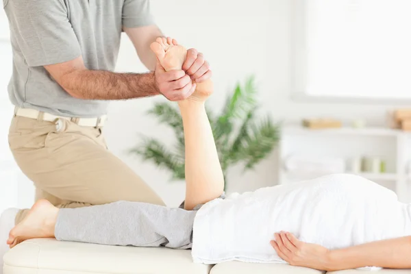 Massaggiatore massaggiando il piede di un cliente — Foto Stock