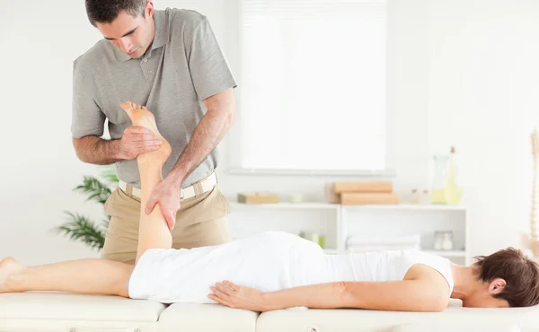 A perna de uma cliente a ser massajada — Fotografia de Stock