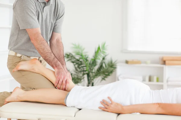 Masajista masajes pierna de mujer — Foto de Stock