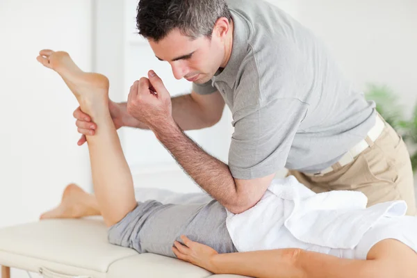 Chiropracteur étire la jambe d'une femme — Photo