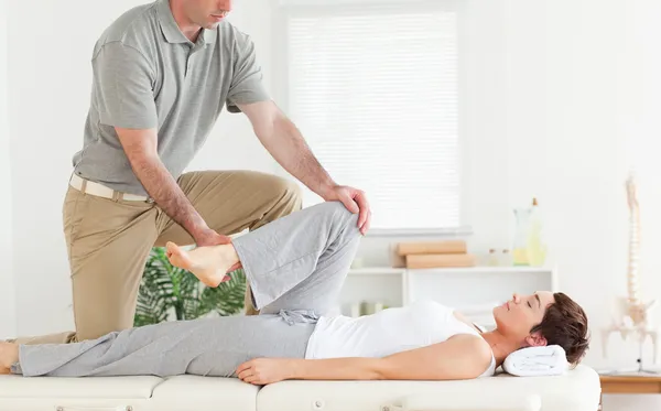 Chiropractor stretches woman's arm — Stock Photo, Image