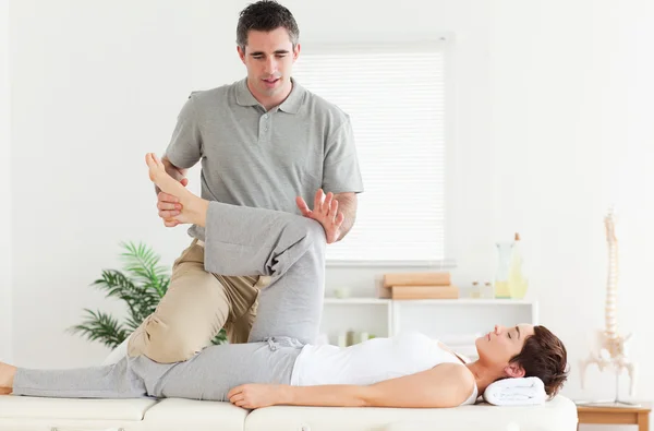 Chiropraktiker streckt einer Frau das Bein — Stockfoto