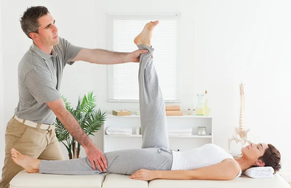 Chiropractor stretching a female's leg — Stock Photo, Image