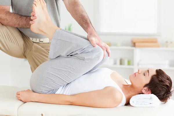 Chiropractor die zich uitstrekt van een vrouw benen — Stockfoto