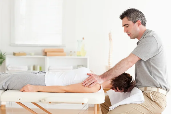 Masseur stretching a woman's head — Stock Photo, Image