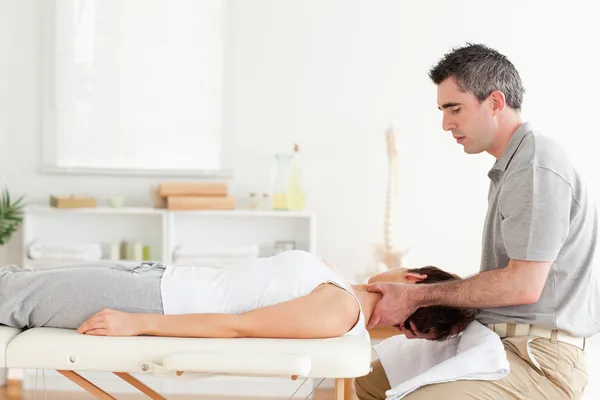 Chiropratico massaggiando il collo della donna — Foto Stock