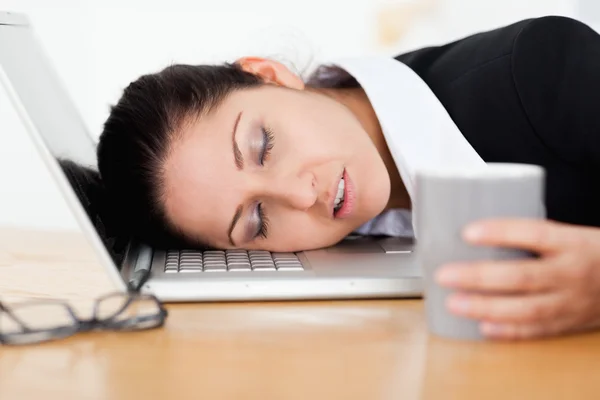 Mujer de negocios durmiendo con una taza de café en la mano —  Fotos de Stock