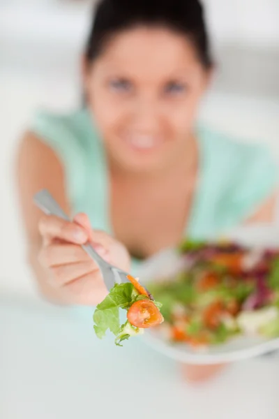 Junge Frau bietet Salat an — Stockfoto