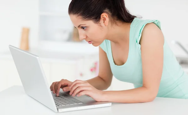 Fiatal nő rajta laptop a konyha — Stock Fotó
