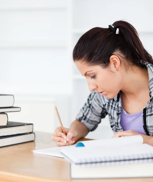 Jonge student schrijven in haar boek exrecise — Stockfoto