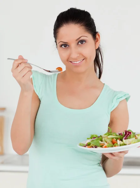 Junge Frau mit Salat blickt in die Kamera — Stockfoto