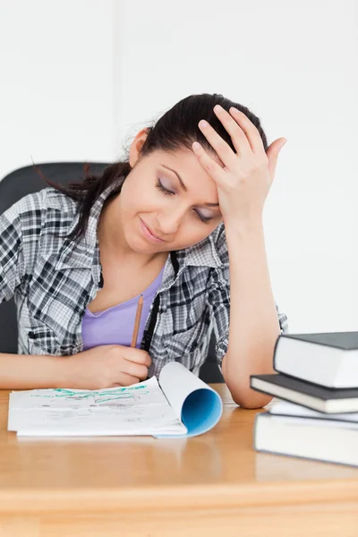Student looking to her homework — Stock Photo, Image