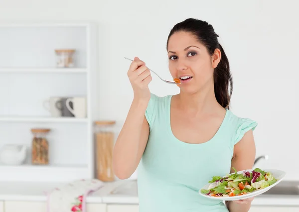 Schöne junge Frau mit Salat in der Küche — Stockfoto