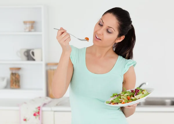 Случайная молодая женщина ест салат — стоковое фото