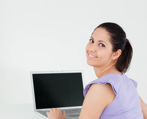 Sorrindo jovem mulher sentada por laptop — Fotografia de Stock