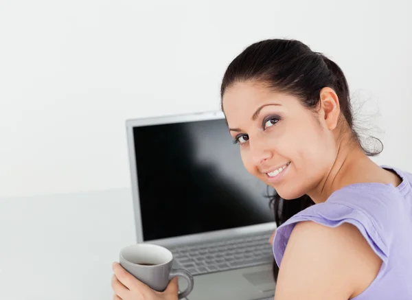 Giovane donna allegra con caffè dal computer portatile — Foto Stock