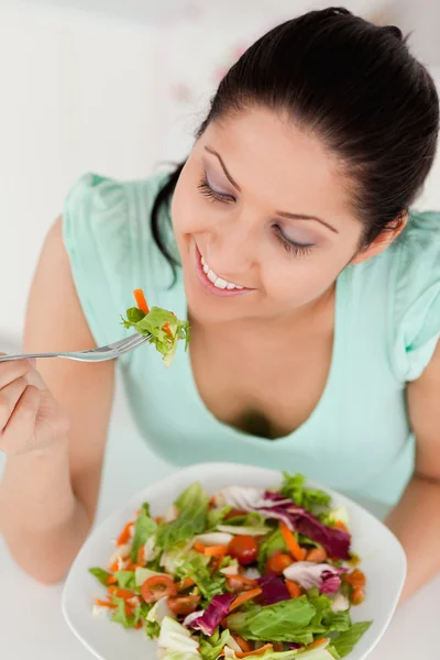 Smiling young female eating salad — Stock Photo, Image