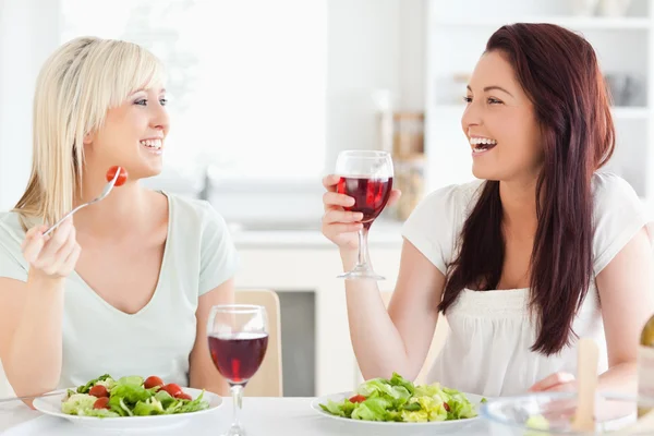 Mladé ženy, pití vína v kuchyni — Stock fotografie