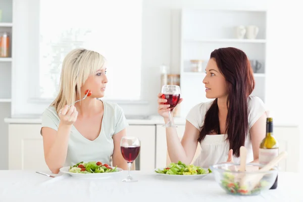 Giovani donne che bevono vino in cucina — Foto Stock