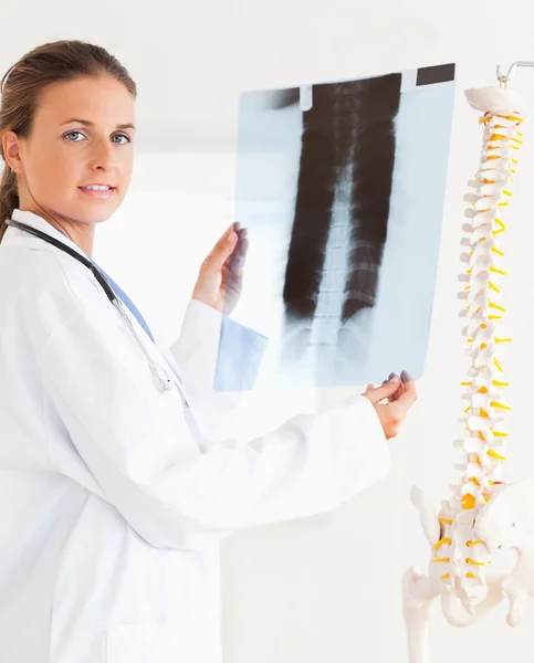 Schöne brünette Ärztin mit Stethoskop und Röntgenbild lizenzfreie Stockfotos
