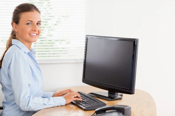 Woman in office looking while typing Stock Picture