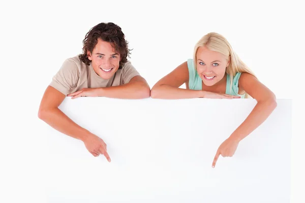 Hombre y mujer linda señalando en una pizarra blanca Fotos de stock