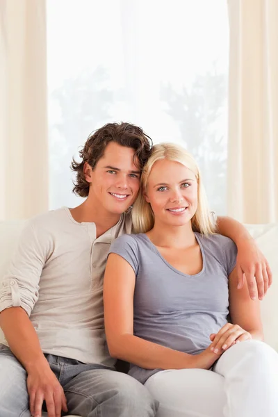 Portrait of a young couple sitting on a sofa Royalty Free Stock Photos