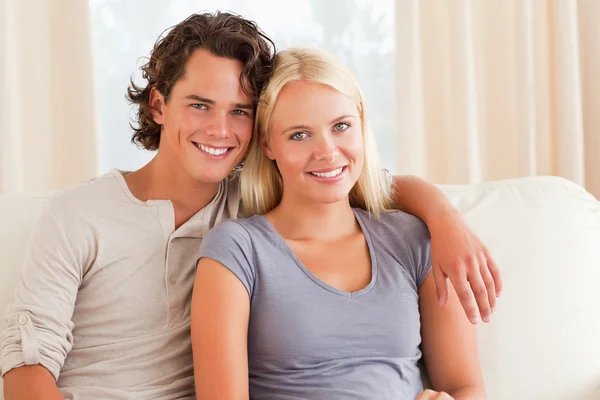 Young couple sitting on a couch Stock Photo