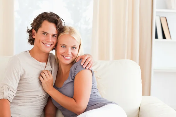 Cheerful couple sitting on a couch Stock Image