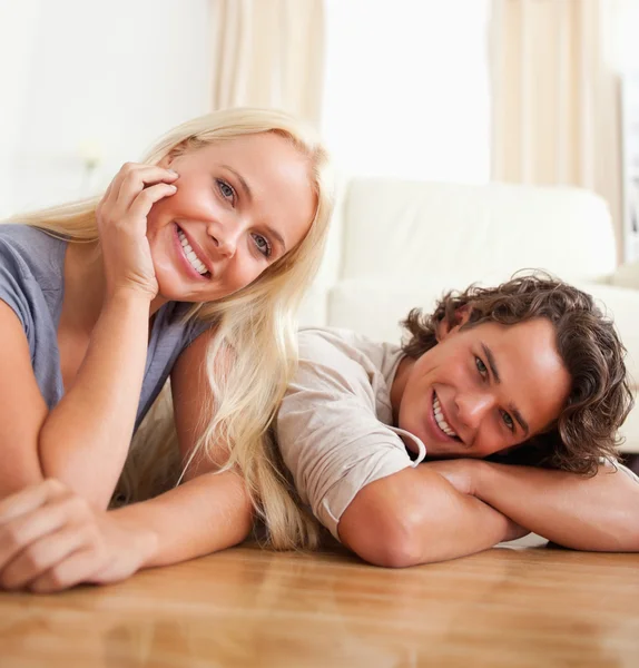 Close up of a cute couple lying on the floor — Stock Photo, Image
